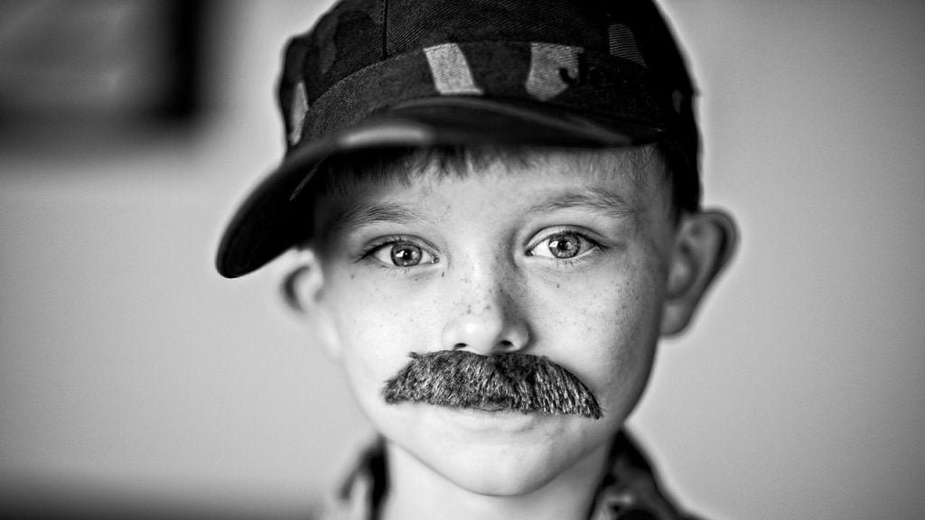 Un enfant déguisé avec une moustache (deepfake image)